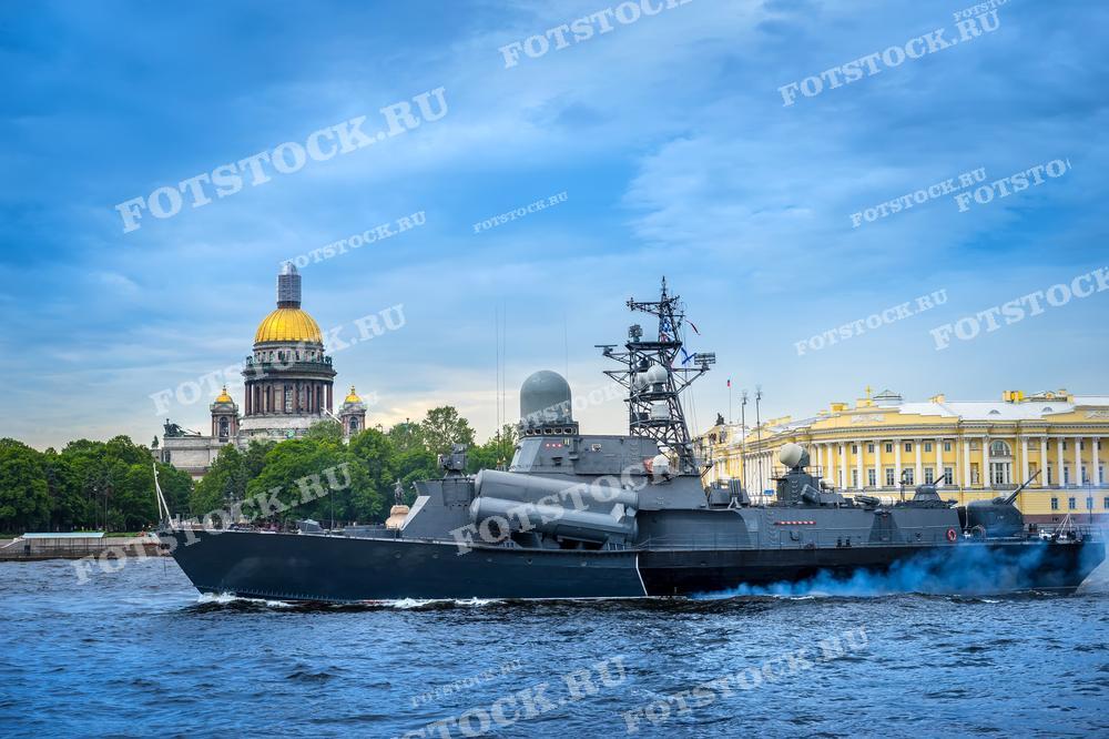 На фото запечатлён военный корабль, плывущий по реке Неве в Санкт-Петербурге на фоне Исаакиевского собора. Собор, с его золотым куполом, выделяется на фоне голубого неба, а жёлтые фасады зданий рядом с ним добавляют яркости композиции. Корабль со своим характерным силуэтом и дымом из трубы создаёт контраст между современностью и историей, миром и военным искусством. Это изображение может быть использовано в публикациях, посвящённых Военно-морскому флоту, истории России, а также в туристических и образовательных материалах.